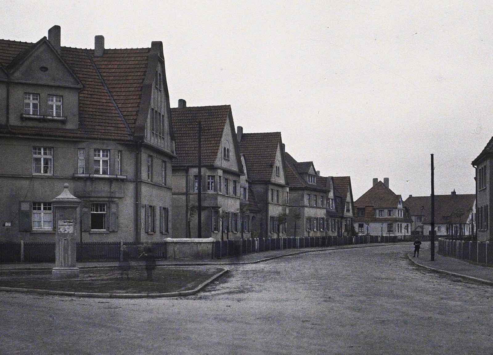 Historisches Farbfoto einer Arbeitersiedlung mit Giebelhäusern und Lattenzäunen