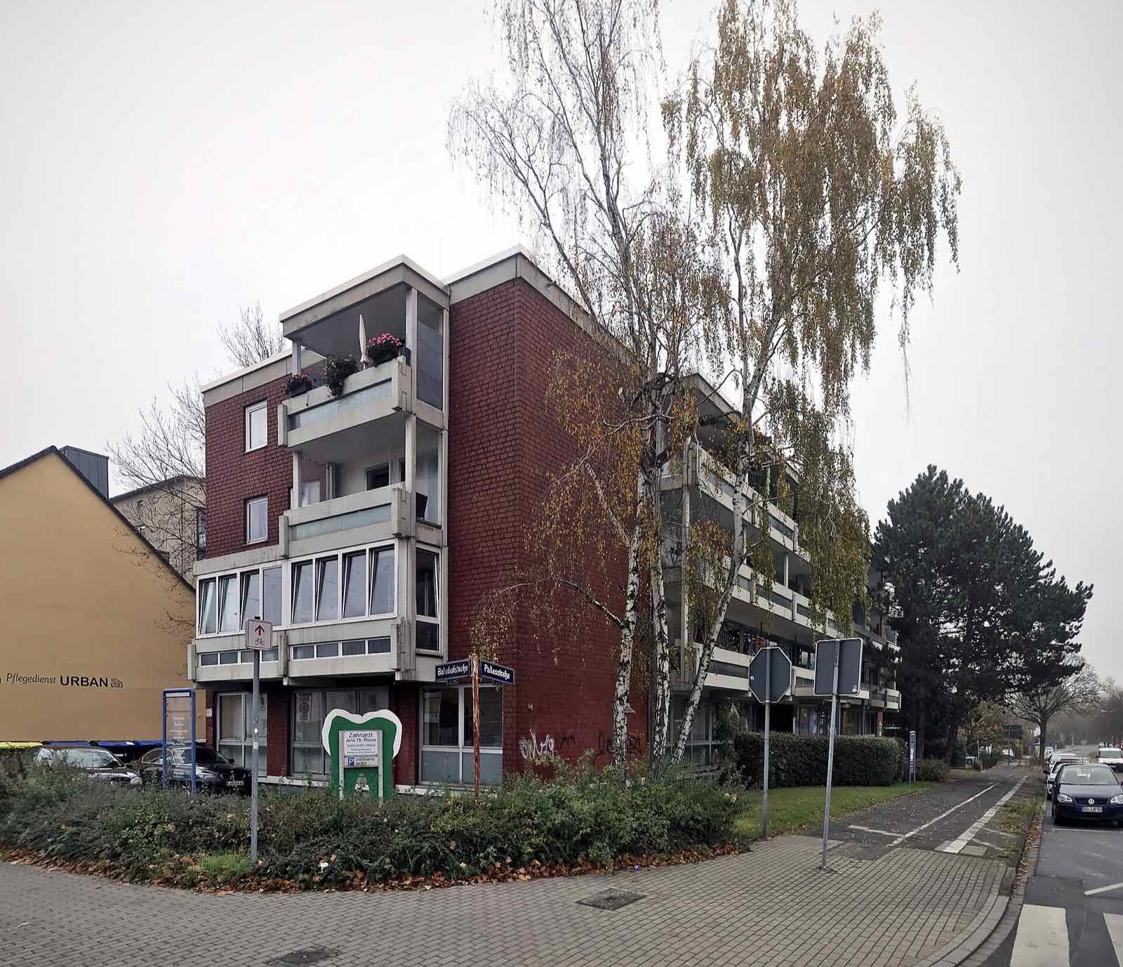 Viergeschossiges Mehrfamilienhaus mit Klinkerfassade und Balkonen an einer Straßenecke